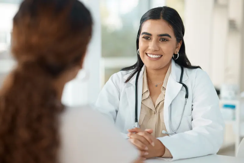 A smiling fertility doctor talking a patient through her results