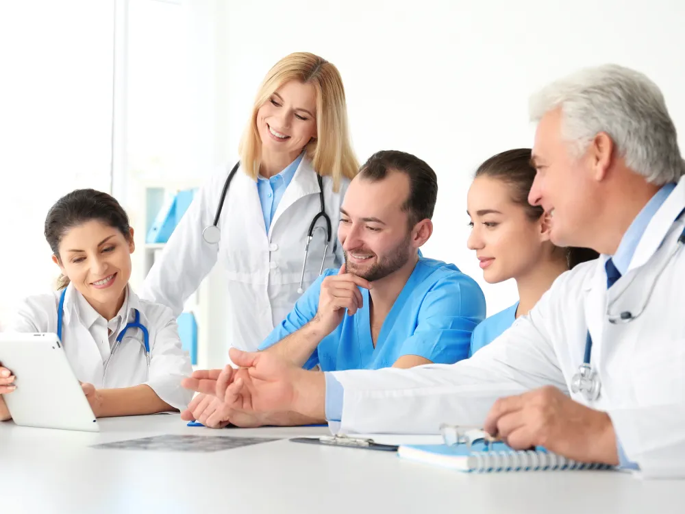 A team of doctors and nurses reviewing a case together around a table