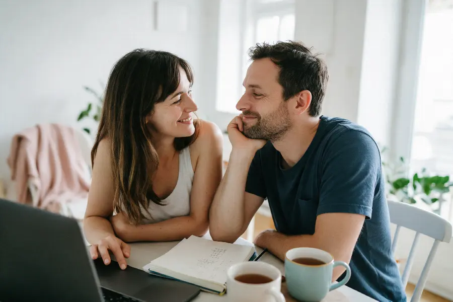 A couple smiling at each other while planning their treatment at home