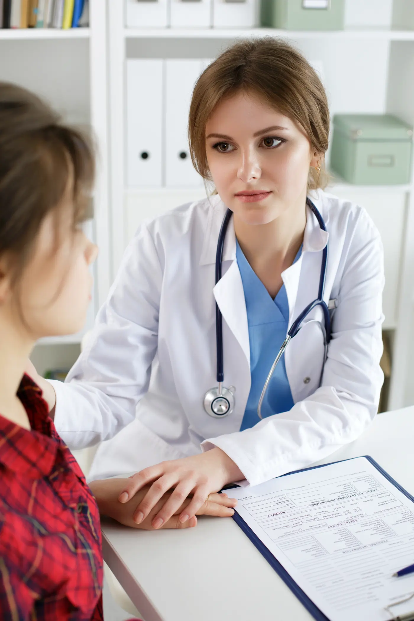 A doctor resting a reassuring hand on her patient's shoulder